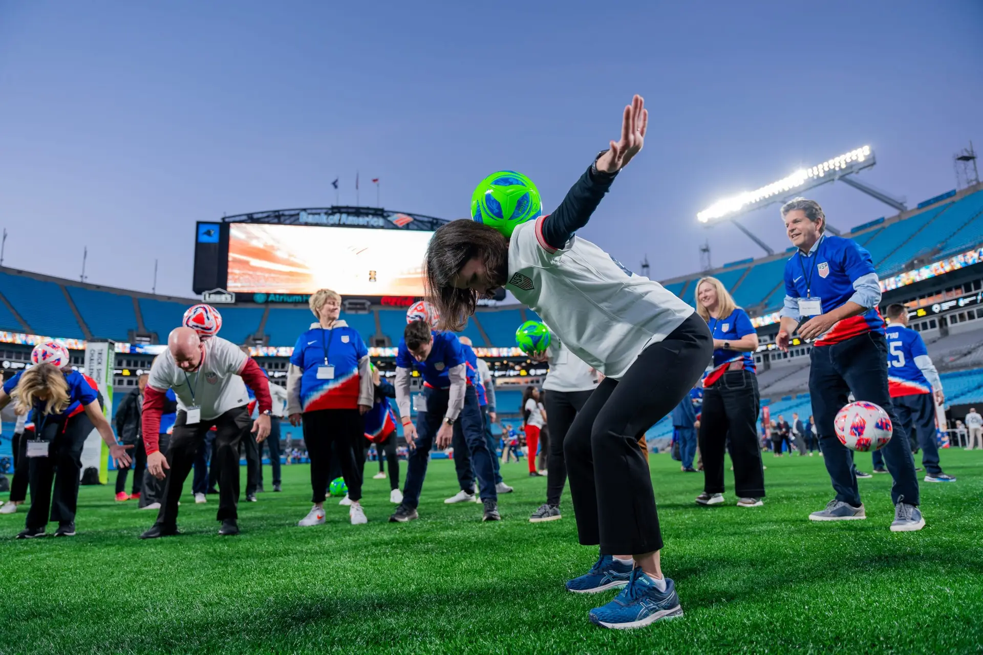 Candid shot of employee kicking soccer ball during team-building activity in Charlotte