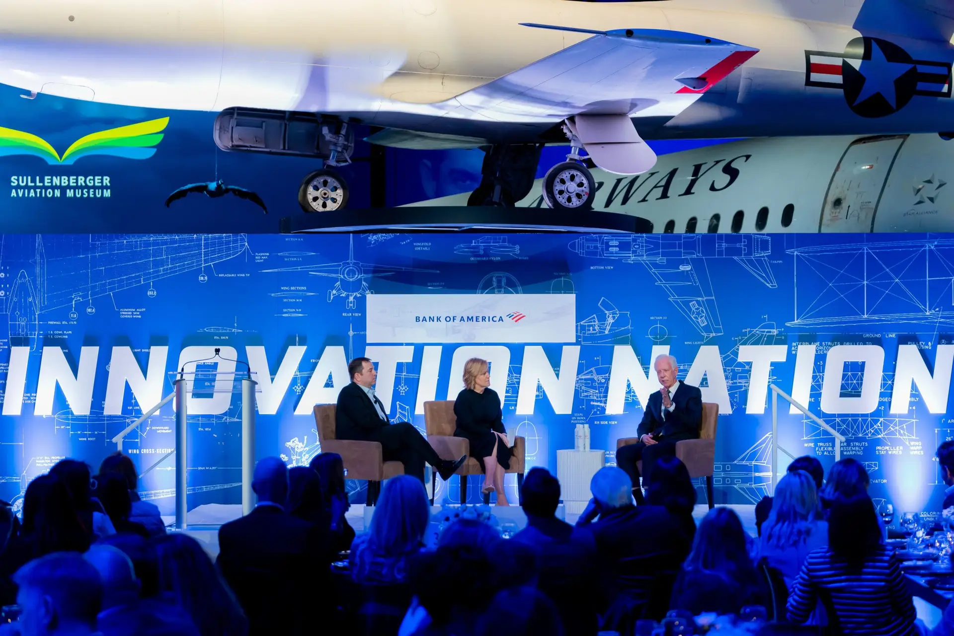 Evening reception guests mingling under the wing of a preserved aircraft at Sullenberger Aviation Museum