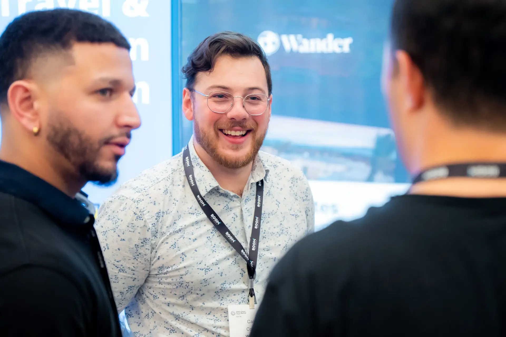 Professional corporate event photography of guests engaging with the Wander team at a conference