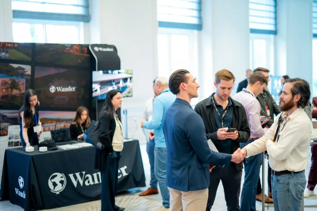 Professional event photography capturing conversations at the Wander exhibit booth